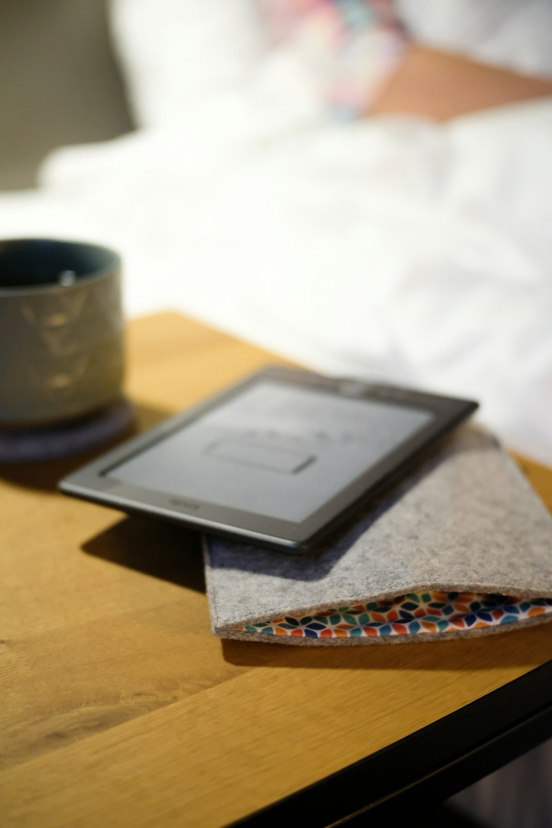 a-table-with-a-tablet-and-a-cup-on-it.jpg A table with a tablet and a cup on it